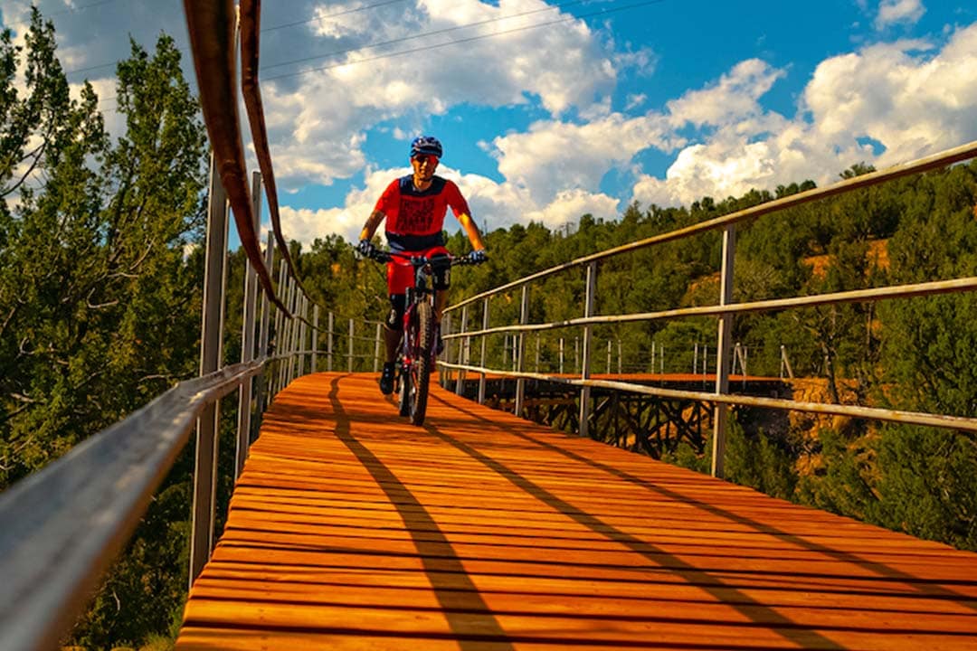 Mountain biker crossing a wooden trestle bridge